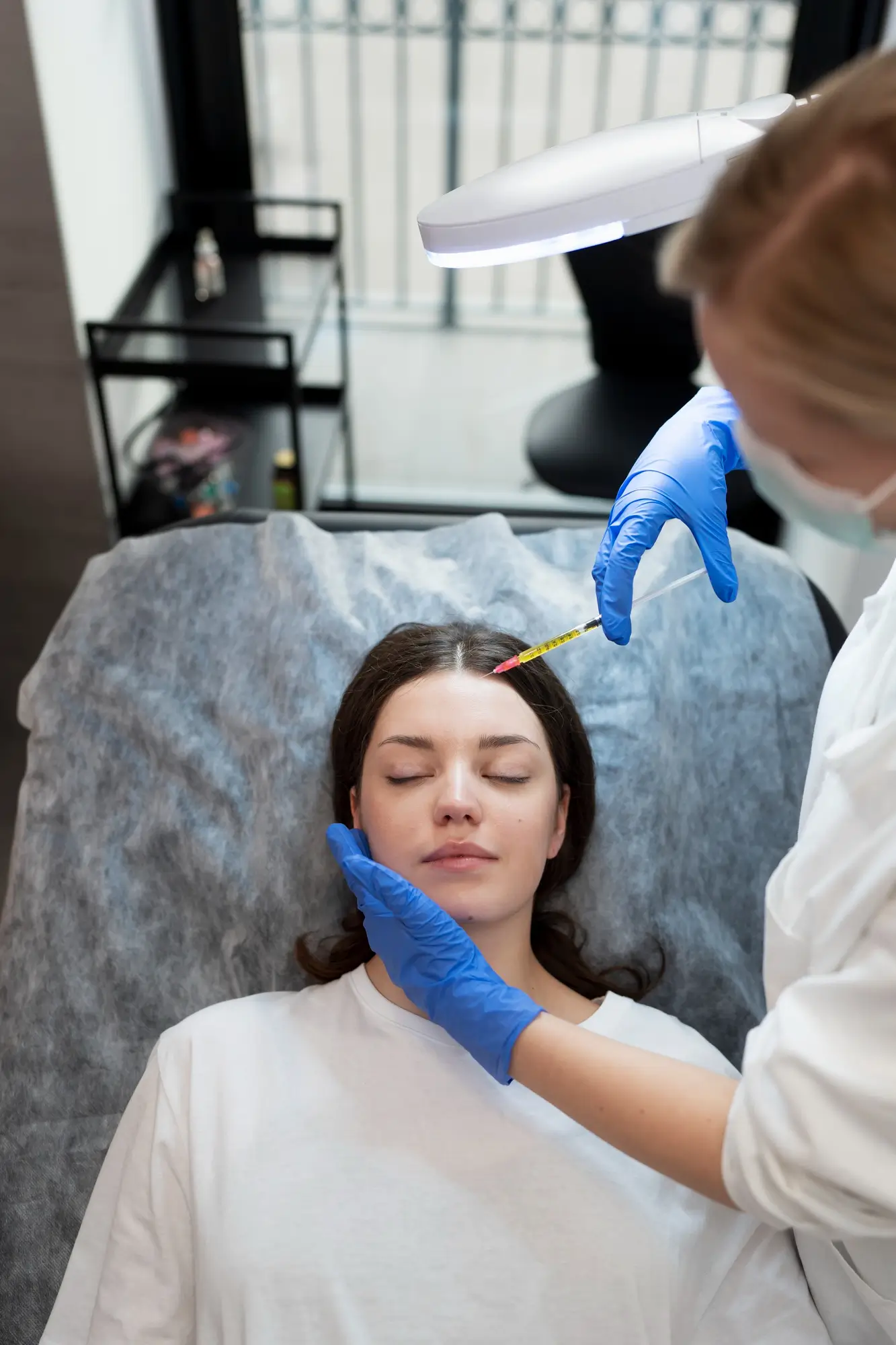 Smiley young woman getting botox injection