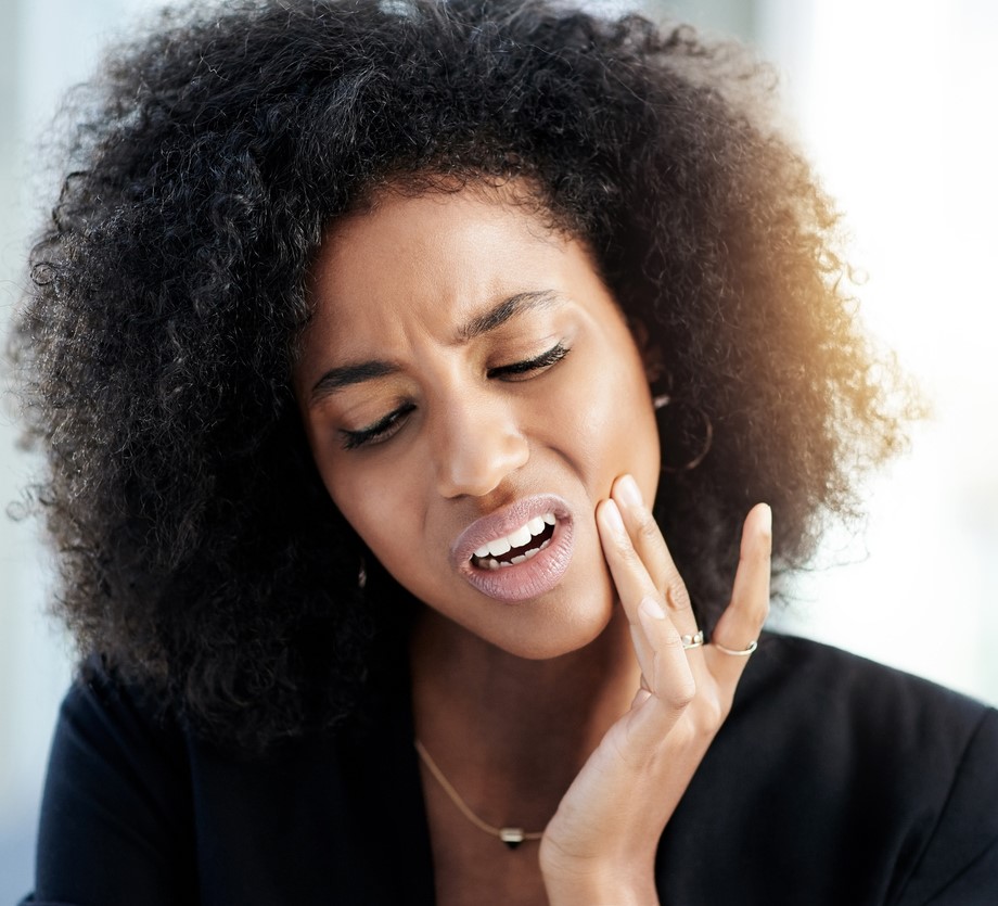 Women holding her hand to her jaw needing TMJ Treatment at Seaside Dentistry in Mobile, AL